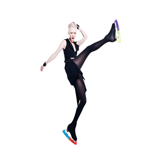 punk lady in black tights with ice skates on kicking the air on a white background 